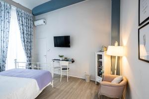 - une chambre avec un lit et une table avec une chaise dans l'établissement Maison Rêve Torino Centro, à Turin
