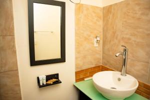 uma casa de banho com um lavatório e um espelho na parede em Cocoplum Rest N Hideaway #1 em Nassau