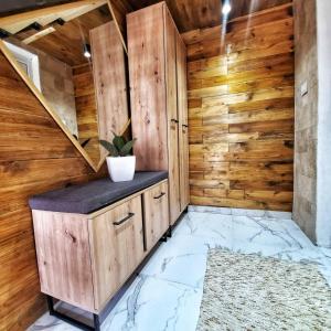 baño con paredes de madera y encimera con maceta en Coratina Cottage en Ulcinj