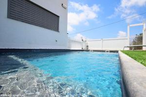 une piscine en face d'un bâtiment dans l'établissement אחוזת אור הנוף, à Shetula