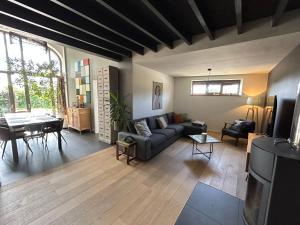 a living room with a couch and a table at La villa du Tilleul in Stoumont