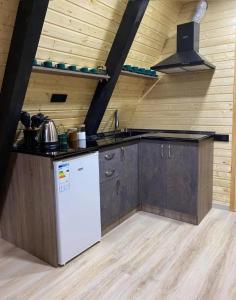 a kitchen with a white refrigerator and wooden walls at Cozy Cottage Dilijan Arg in Dilijan