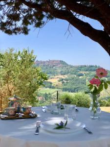 un tavolo con una tovaglia bianca e un vaso con fiori di Colle Costanza a Todi