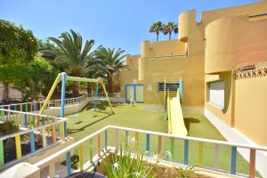 a playground in front of a house with a slide at Book Jet - Atlantic Dream Apartment & wifi in Corralejo