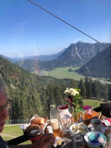 a person sitting at a table with food on it at Wiestalerhof in Bichlbach