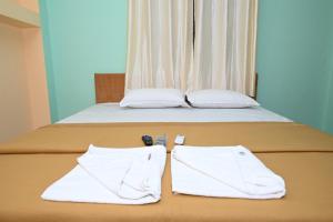 a bed with two white towels on top of it at ROYAL SEAVIEW RESIDENCY in Port Blair