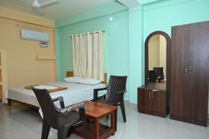 una camera con letto, tavolo e sedie di ROYAL SEAVIEW RESIDENCY a Port Blair