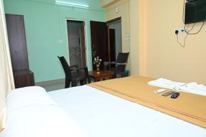 een hotelkamer met een bed en een tafel en stoelen bij ROYAL SEAVIEW RESIDENCY in Port Blair