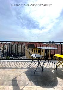 a table and chairs on a balcony with buildings at The 6th floor flat - direct link to centre in 8 mins in Milan