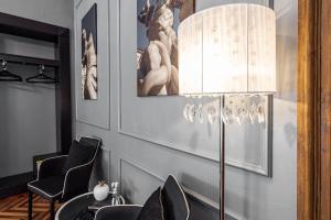 una sala da pranzo con tavolo, sedie e lampada di Maison Rêve Torino Centro a Torino