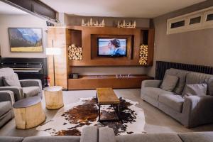 sala de estar con sofá y TV en Riu Nere Mountain Hotel, en Vielha