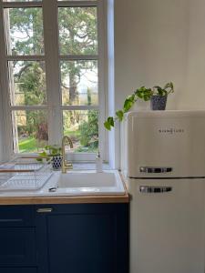 een keuken met een wastafel, een koelkast en een raam bij Bright Apt 70m2 in Bayeux historic center w Pkg in Bayeux