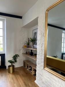 a living room with a large mirror on the wall at Bright Apt 70m2 in Bayeux historic center w Pkg in Bayeux