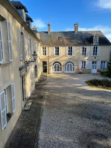 - un ancien bâtiment avec une allée devant dans l'établissement Bright Apt 70m2 in Bayeux historic center w Pkg, à Bayeux