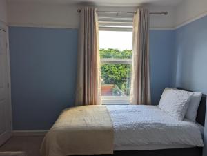 a bedroom with a bed and a window with a view at Gull Wing Guesthouse in Lowestoft