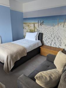 a bedroom with a bed and a couch on the beach at Gull Wing Guesthouse in Lowestoft