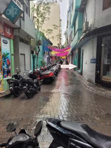 uma fila de motocicletas estacionadas numa rua da cidade em Ontrack Travel em Malé