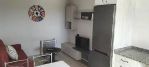 a small kitchen with a black refrigerator and a table at RECUNCHIÑO in San Xoán de Río