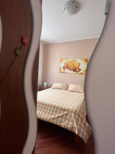 Dormitorio pequeño con cama y espejo en Your Friend in Rome, en Roma