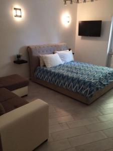 ein Schlafzimmer mit einem Bett mit Kissen und einem Sofa in der Unterkunft Royal Apartment in Ciampino