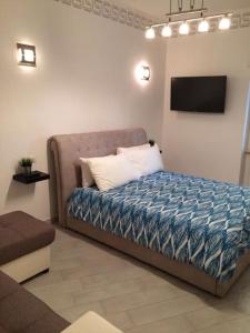 a bedroom with a bed with a tv on the wall at Royal Apartment in Ciampino