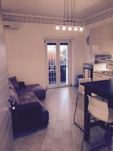 ein Wohnzimmer mit einem Sofa und einem Tisch sowie eine Küche in der Unterkunft Royal Apartment in Ciampino