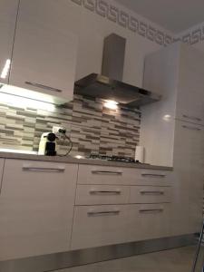 a kitchen with white cabinets and a stove at Royal Apartment in Ciampino