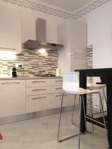 eine Küche mit weißen Schränken und einer weißen Arbeitsplatte in der Unterkunft Royal Apartment in Ciampino