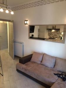 ein Wohnzimmer mit einem braunen Sofa in einem Zimmer in der Unterkunft Royal Apartment in Ciampino