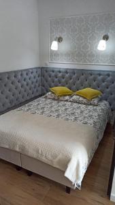 a bedroom with a large bed with yellow pillows at Apartament na Starówce in Elblag