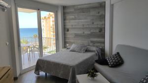 a bedroom with a bed and a balcony with the ocean at Estudio SHEILA in Torrox Costa