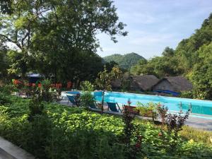 a swimming pool at a resort with mountains in the background at Catba Papillon Garden Bungalows & Resort in Cat Ba
