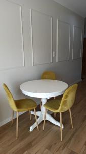Biały stół i dwa krzesła oraz biały stół i krzesła w obiekcie Apartament na Starówce w Elblągu