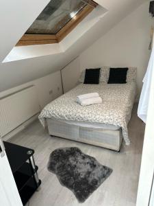a bedroom with a bed and a rug on the floor at Cozy Urban Terraced Studio in London