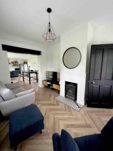 Ballybur Cottage في كيلكيني: غرفة معيشة مع أريكة ومدفأة
