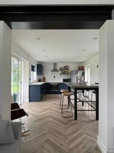 a living room with a table and a kitchen at Ballybur Cottage in Kilkenny