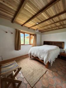 - une chambre avec un lit et un plafond en bois dans l'établissement Los Viajeros B&B, à Leimebamba