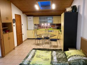 a room with a kitchen and a table and chairs at Horváth Apartmanház in Szigliget