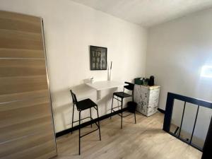 une chambre avec une table blanche et deux chaises dans l'établissement Studio calme hyper-centre, à Grenoble