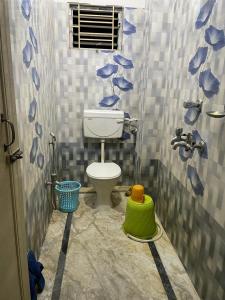 łazienka z toaletą w wyłożonej kafelkami łazience w obiekcie Veda Homestay w mieście Agartala