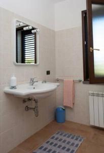 W łazience znajduje się umywalka i lustro. w obiekcie Agriturismo Serra Maiori w mieście Tramatza