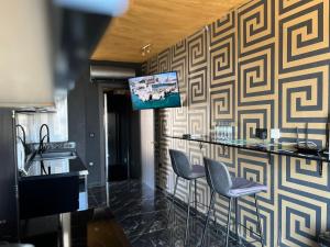 Luxury Penthouse in Sliema في سليمة: بار به كراسي وتلفزيون على الحائط