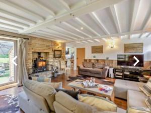 uma sala de estar com um sofá e uma mesa em Luxury Country Cottage With A View em Enstone