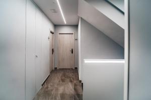 a hallway with white cabinets and a door at Arevalos Hotel in Cuenca