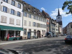 eine Straße in einer Stadt mit Gebäuden und einer Kirche in der Unterkunft Au Quai Des Pecheurs in Straßburg