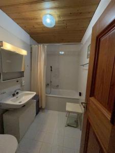 y baño con lavabo y bañera. en Casa Lalla affittasi nel centro di Poschiavo, en Poschiavo