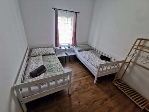 três camas num quarto com uma janela em Vejminek Malý Statek 