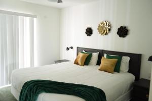 a bedroom with a large bed with green and white pillows at Enchanting Escape 3 Bedroom Minutes from Disney! in Kissimmee