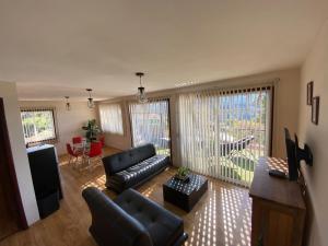 a living room with a couch and a television at Cabañas Tr'eje in Valle de Bravo
