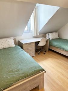 1 dormitorio con 2 camas, escritorio y silla en Large Quiet Whole House near Historic Gent Centre, en Gante